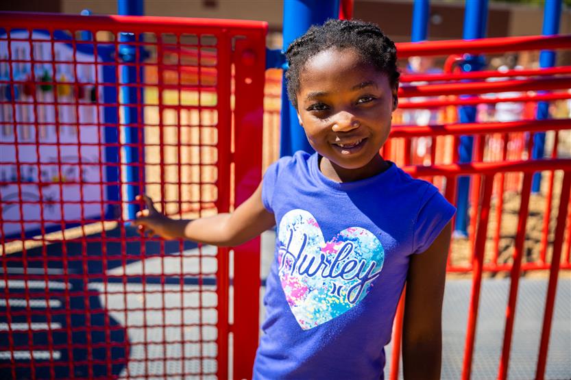 A girl wearing a purple shirt smiles